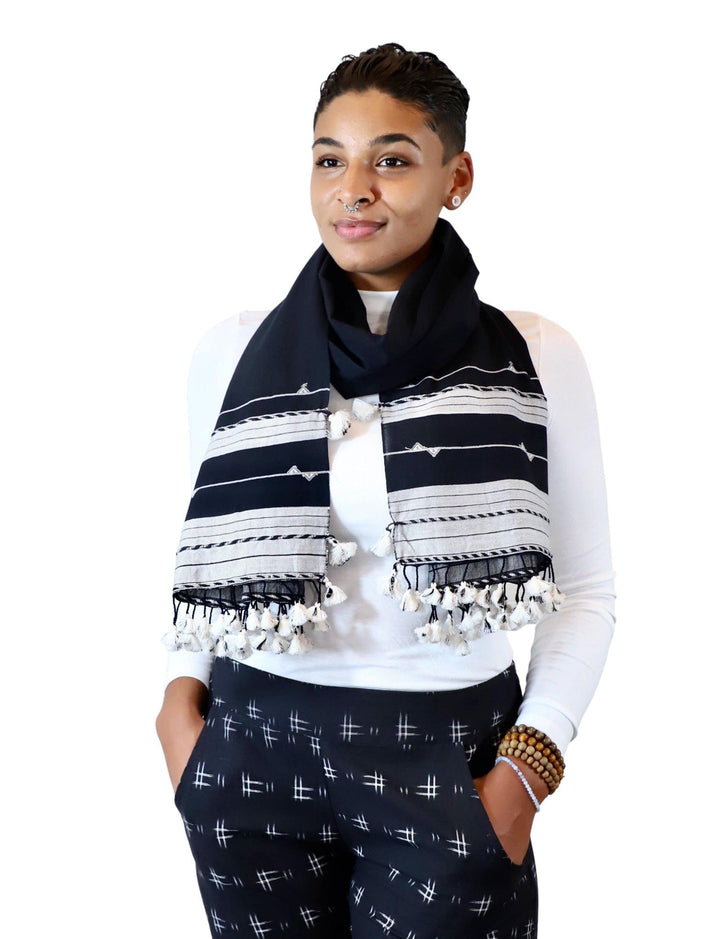 Black handwoven cotton scarf with geometric patterns and parallel stripes laid flat showing intricate Kutch weaving