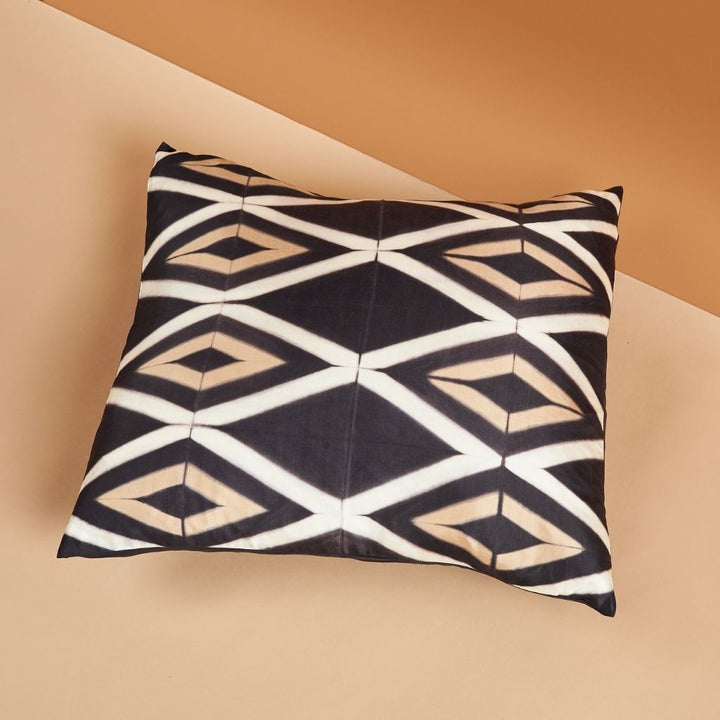 Handcrafted black gold white geometric shibori print silk pillow with natural dyes on neutral background