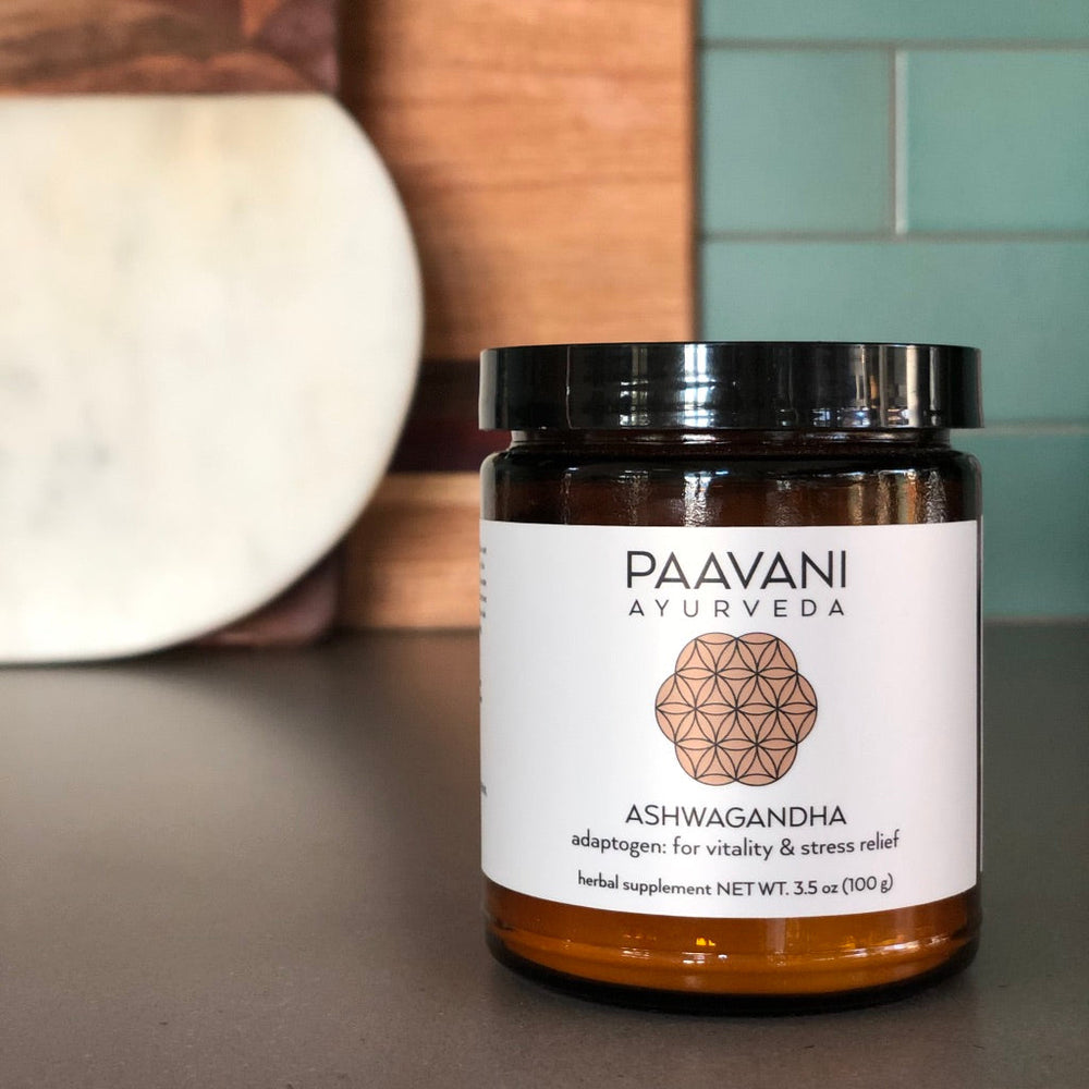 Jar of Paavani Ayurveda Ashwagandha powder on kitchen counter, adaptogenic supplement for stress relief and vitality.