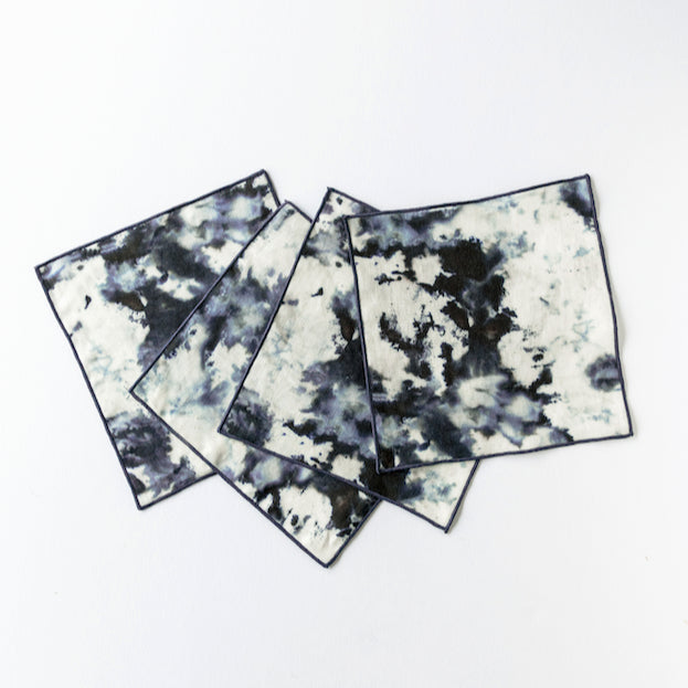 Grey marble pattern linen cocktail napkins with elegant trim displayed on table setting