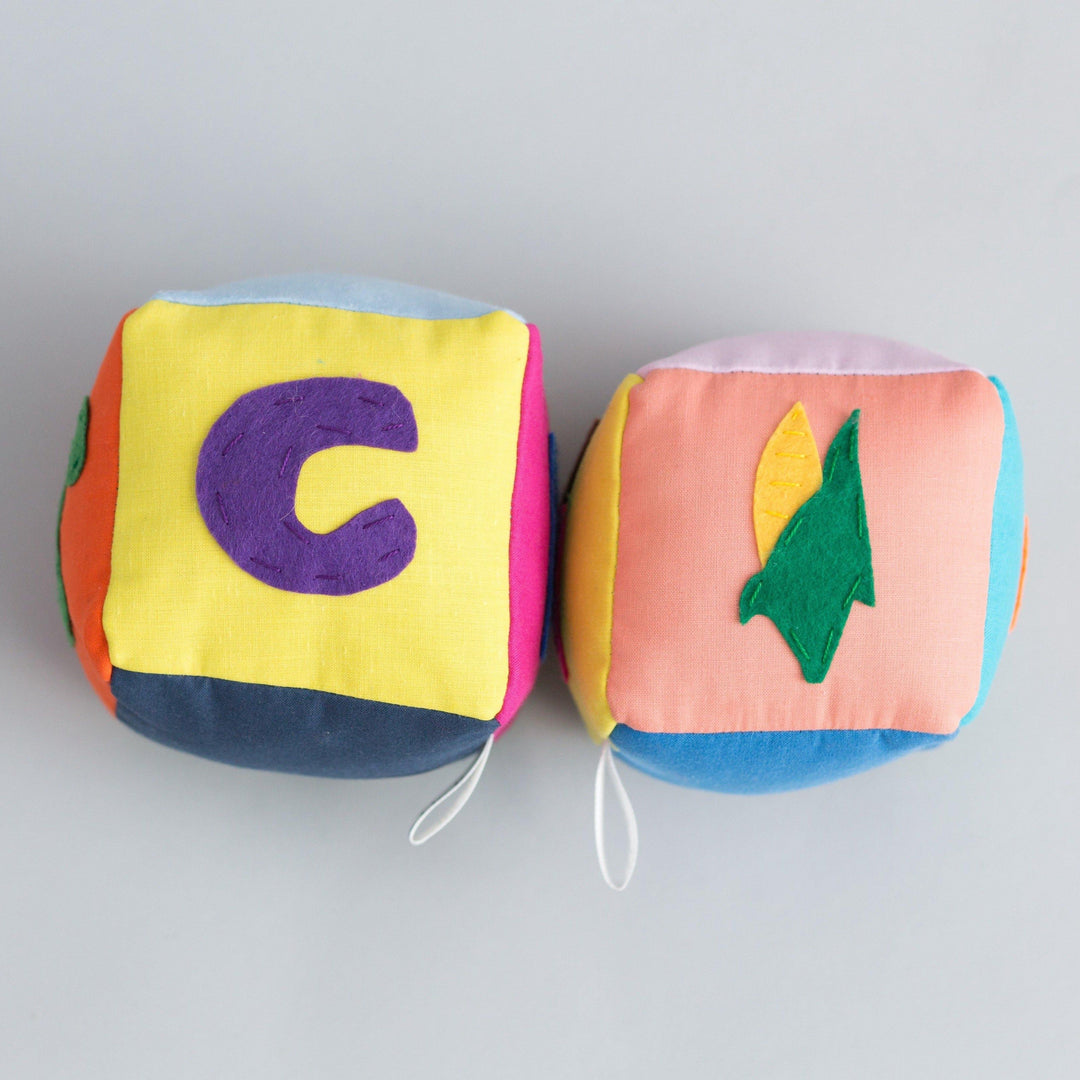 Two handmade educational fabric blocks with vegetable images and letters for children's learning