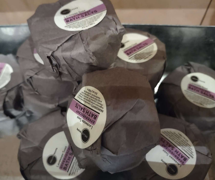 Stack of effervescent bath fizzies with jojoba oil and silk proteins, wrapped in biodegradable paper, for a luxurious self-care bath.