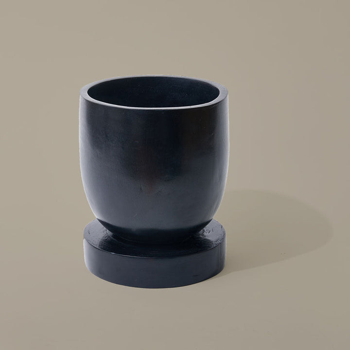 Dark stained hand carved wooden planter elevated on legs made from sustainable Sese Wood in Ghana