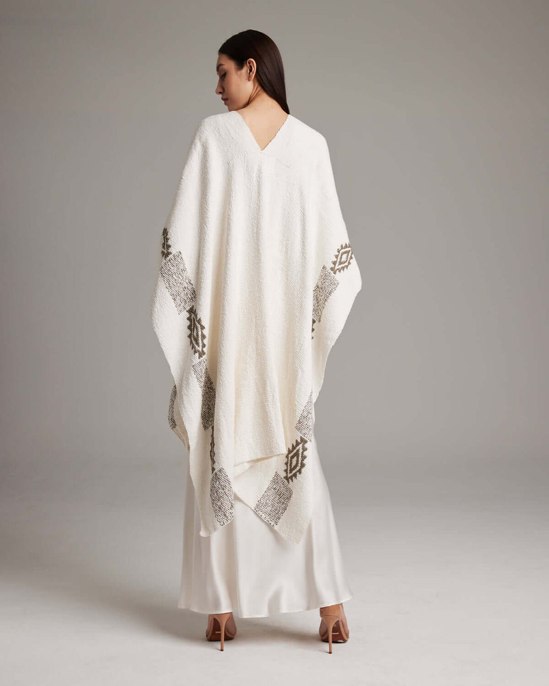 Woman wearing a long Estrella textured cotton duster with poncho design, handcrafted from organic Pima cotton by Mapuche artisans.