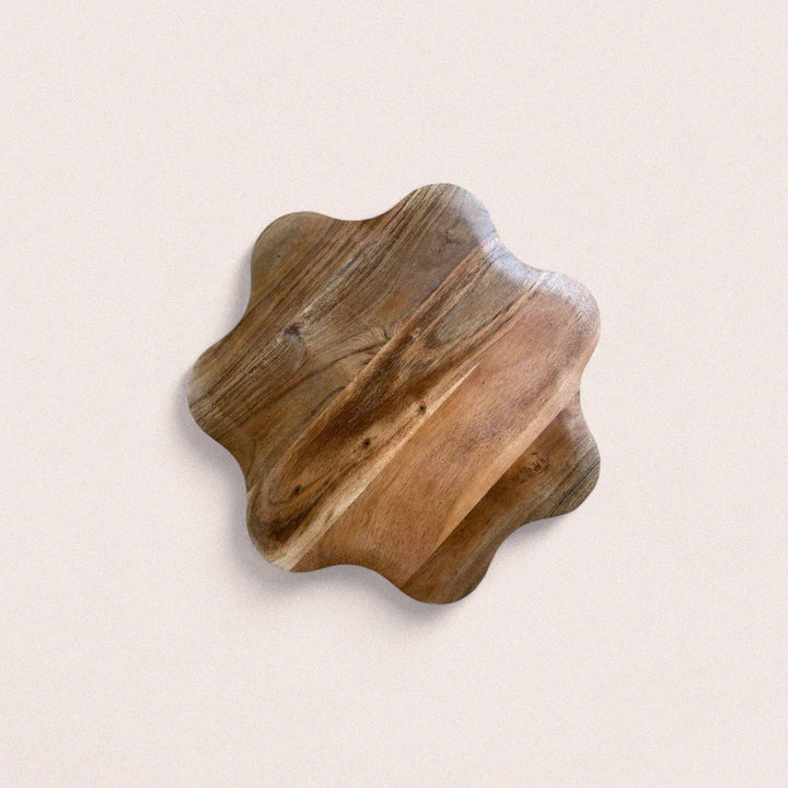 Large round acacia wood serving board with natural grain patterns displayed on white background