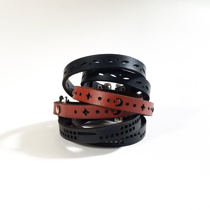 Leather double wrap bracelet with sun and moon design, laser cut nature and geometric patterns, adjustable fit, shown coiled.