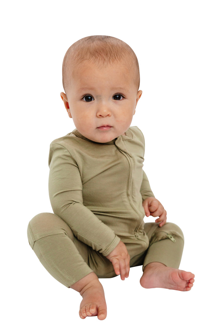 Baby wearing Luxe Bamboo Baby Pajamas in Moss Green with fold-over footie, two-way zipper, and zipper guard for comfort, sitting on white background.
