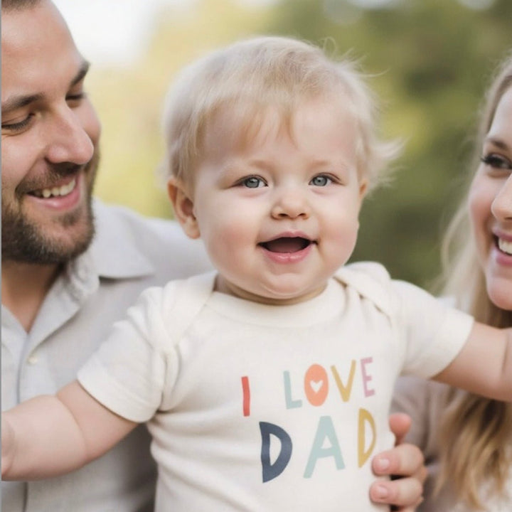 Organic cotton baby bodysuit with Love Dad graphic design in soft natural colors
