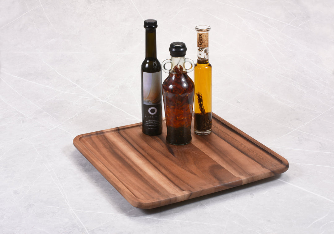 Square Acacia Lazy Susan holding bottles, showcasing smooth rotation on tabletop, ideal for spices and condiments.