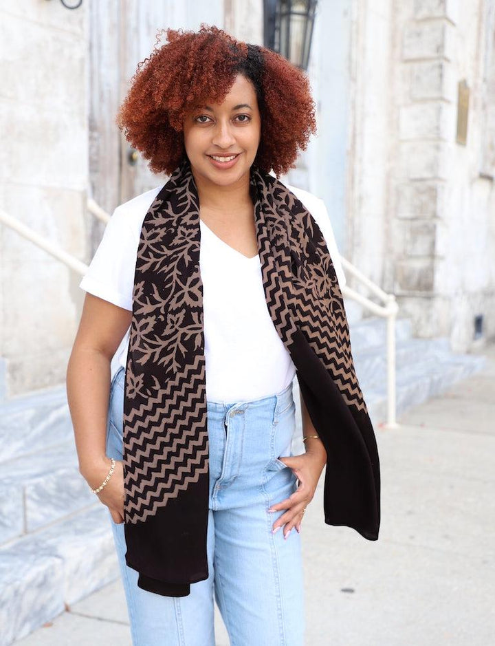 Black modal scarf with hand block printed peachy beige floral and zigzag stripe pattern draped elegantly