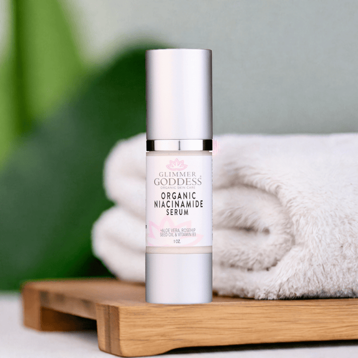 Bottle of Organic Niacinamide Anti Aging Serum on wooden tray with towels