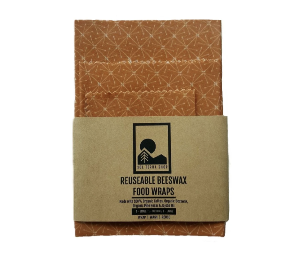 Eco-friendly beeswax food wraps made of organic cotton, beeswax, jojoba oil, and pine resin, shown in packaging.