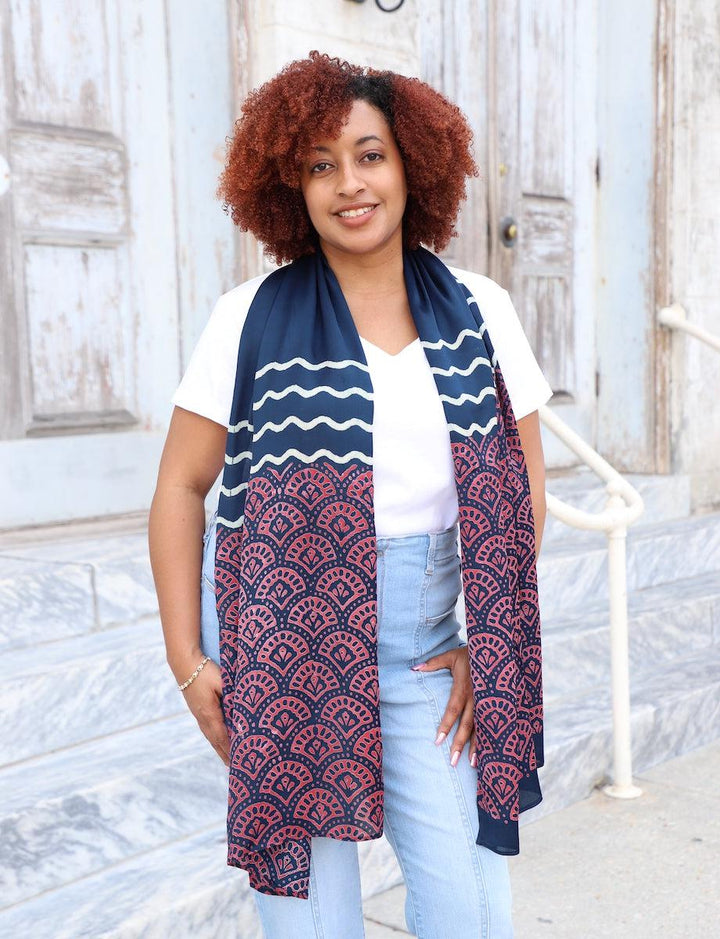 Deep blue modal scarf with pink lotus block print pattern and white wavy border draped elegantly