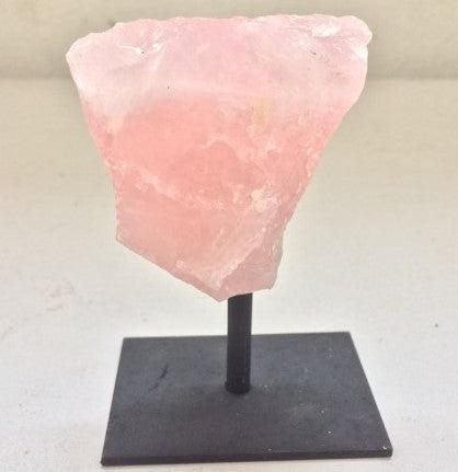 Natural rose quartz crystal on iron metal stand displaying soft pink stone formations for home decor