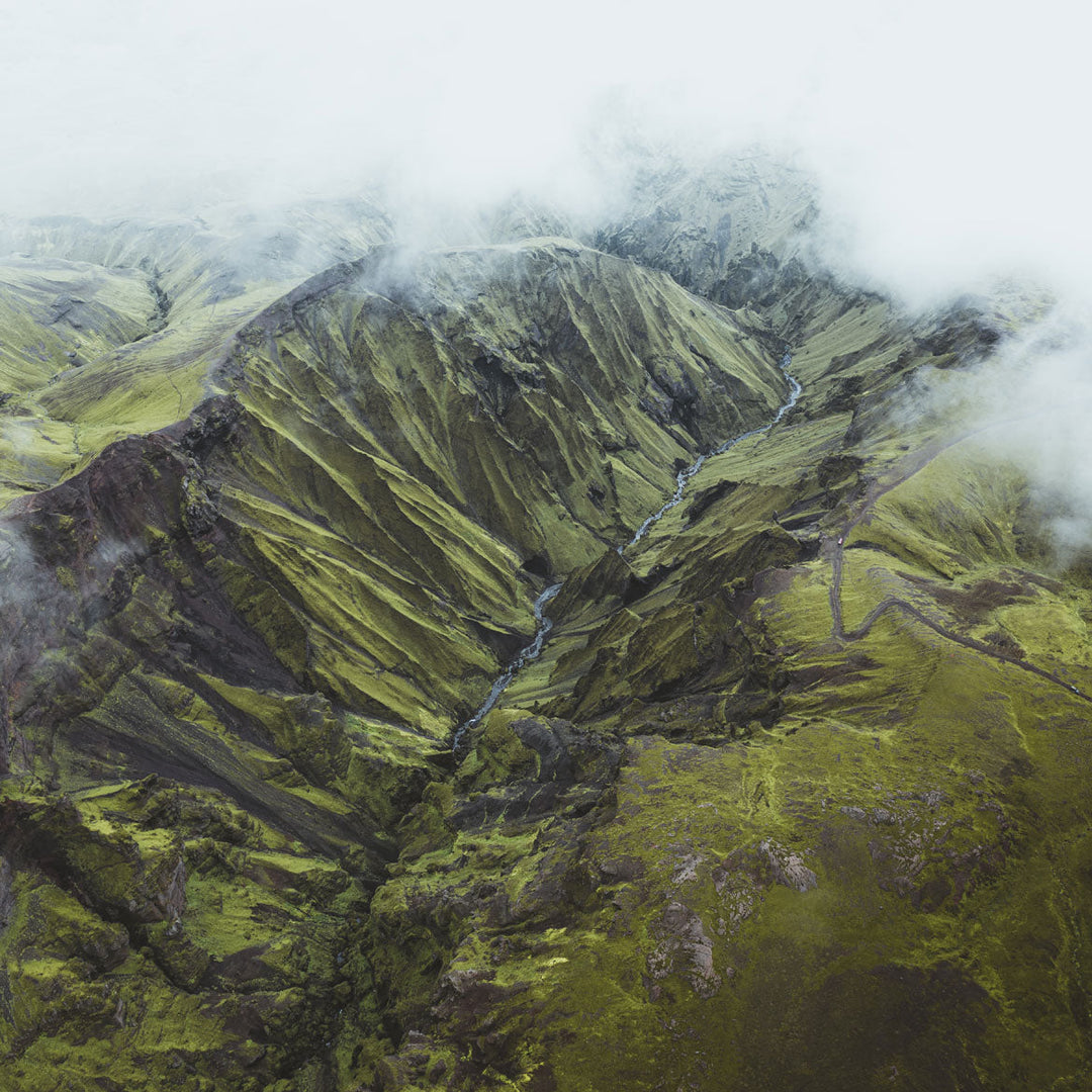 Aerial view of Icelandic Highlands with lush green valleys and mist, evoking the essence of Arctic thyme's natural habitat.