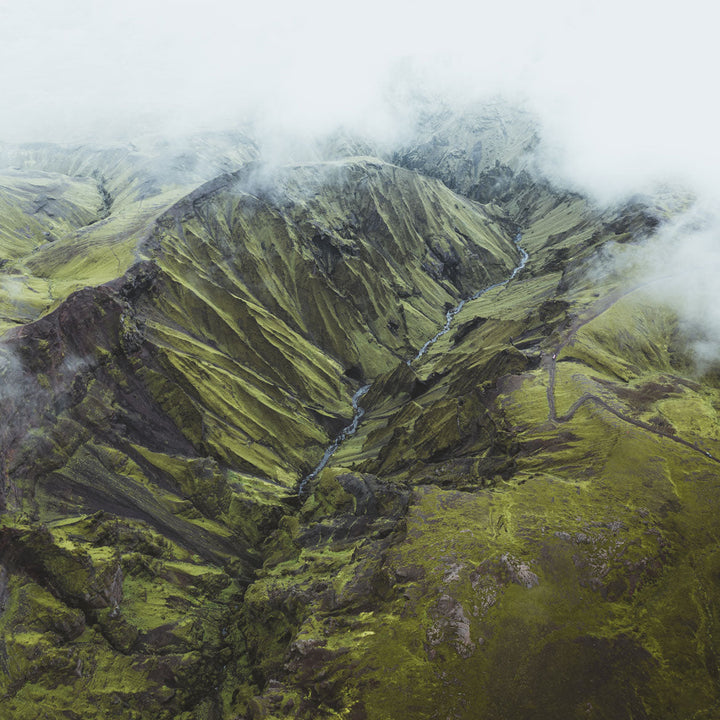 Aerial view of Icelandic Highlands with lush green valleys and mist, evoking the essence of Arctic thyme's natural habitat.