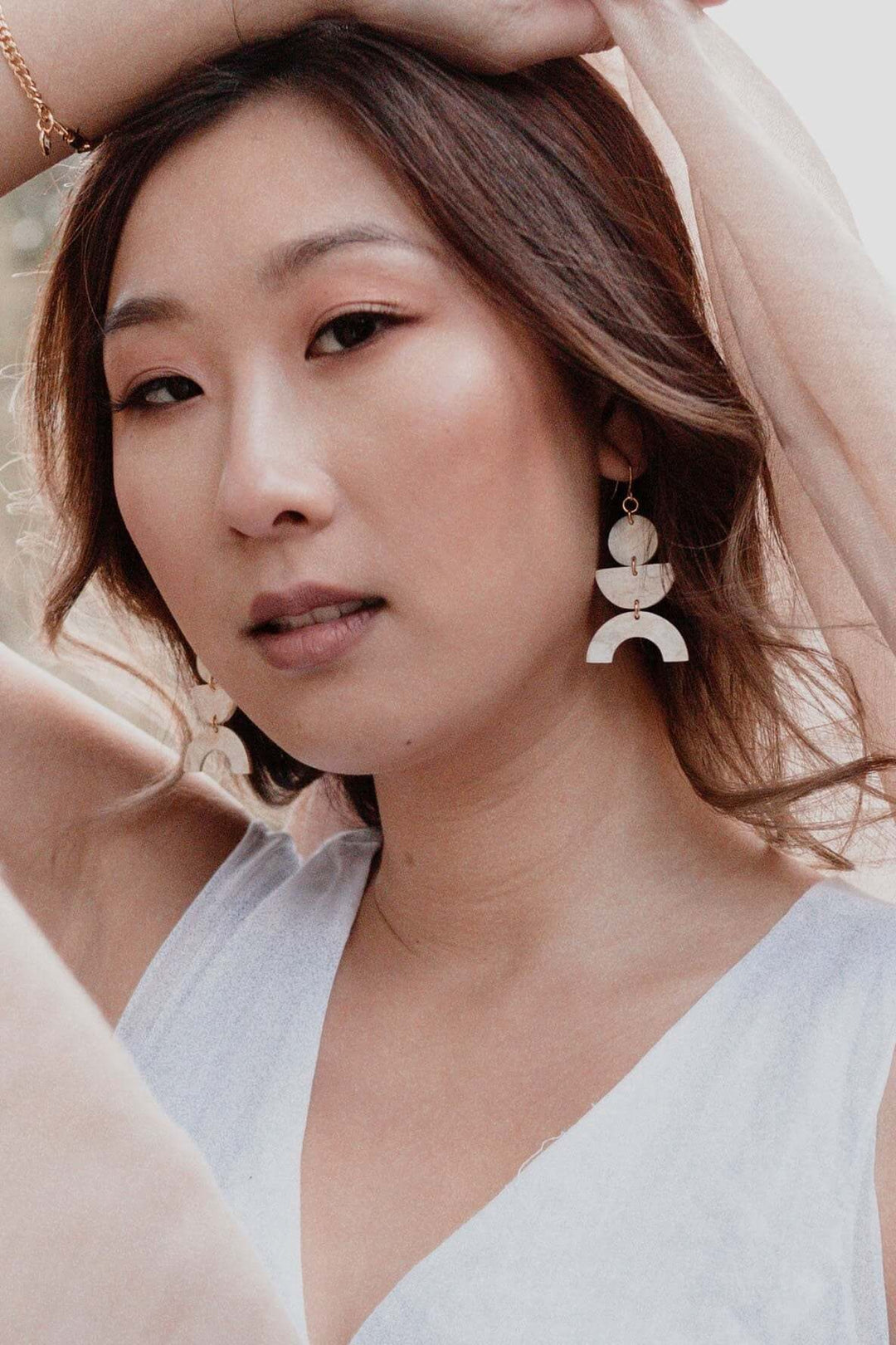 Model wearing Vui Mung Geometric Buffalo Horn Statement Earrings with gold-plated hooks, handcrafted and natural design.