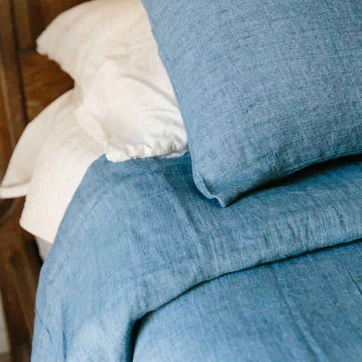 Denim blue linen duvet cover set made from Belgian flax, showcasing soft texture and artisan craft by Creative Women. Luxurious bed linen.