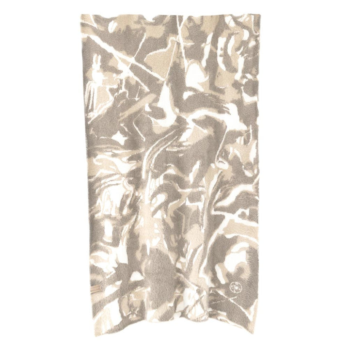 Oversized plush throw blanket in neutral mushroom sand and soft white swirl pattern draped over furniture